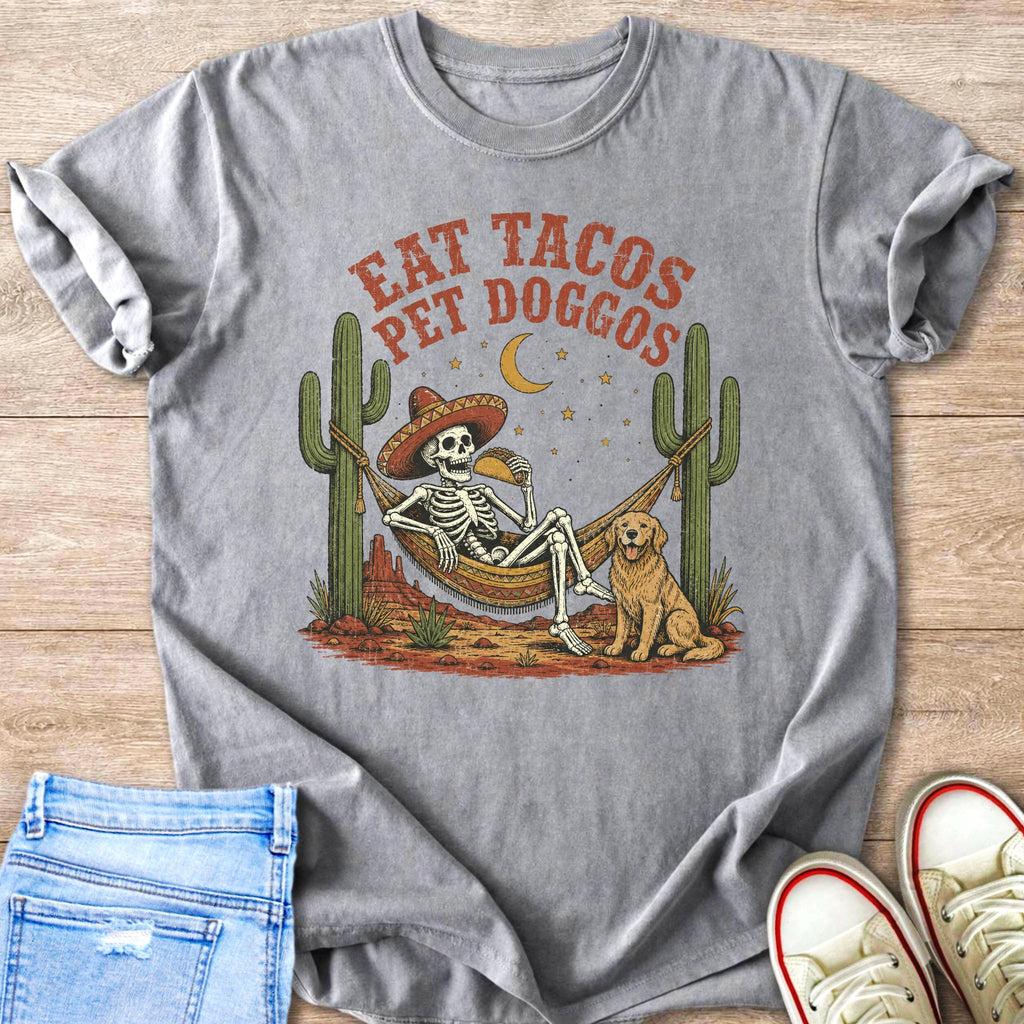 Skeleton in hammock eating taco with dog, saying "Eat Tacos Pet Doggos."