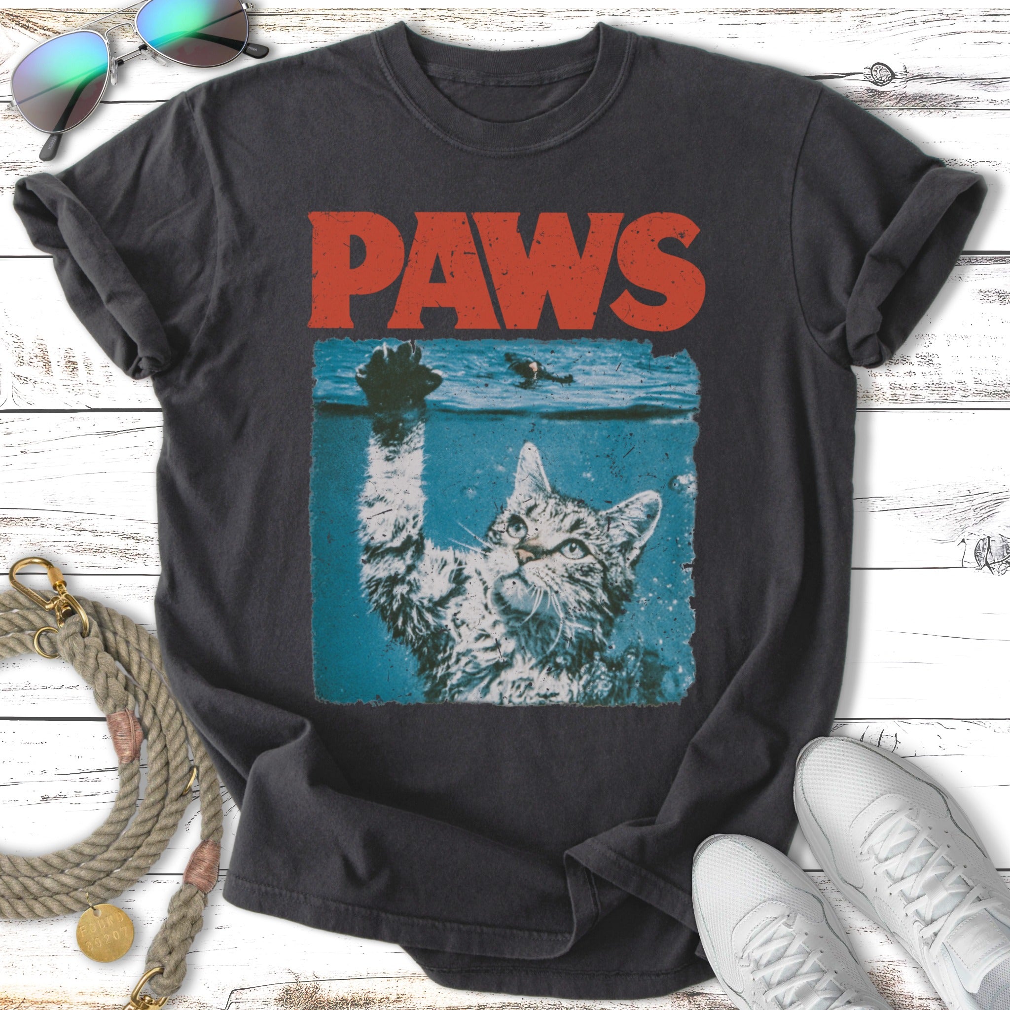 Cat reaching out of water with "PAWS" text above.