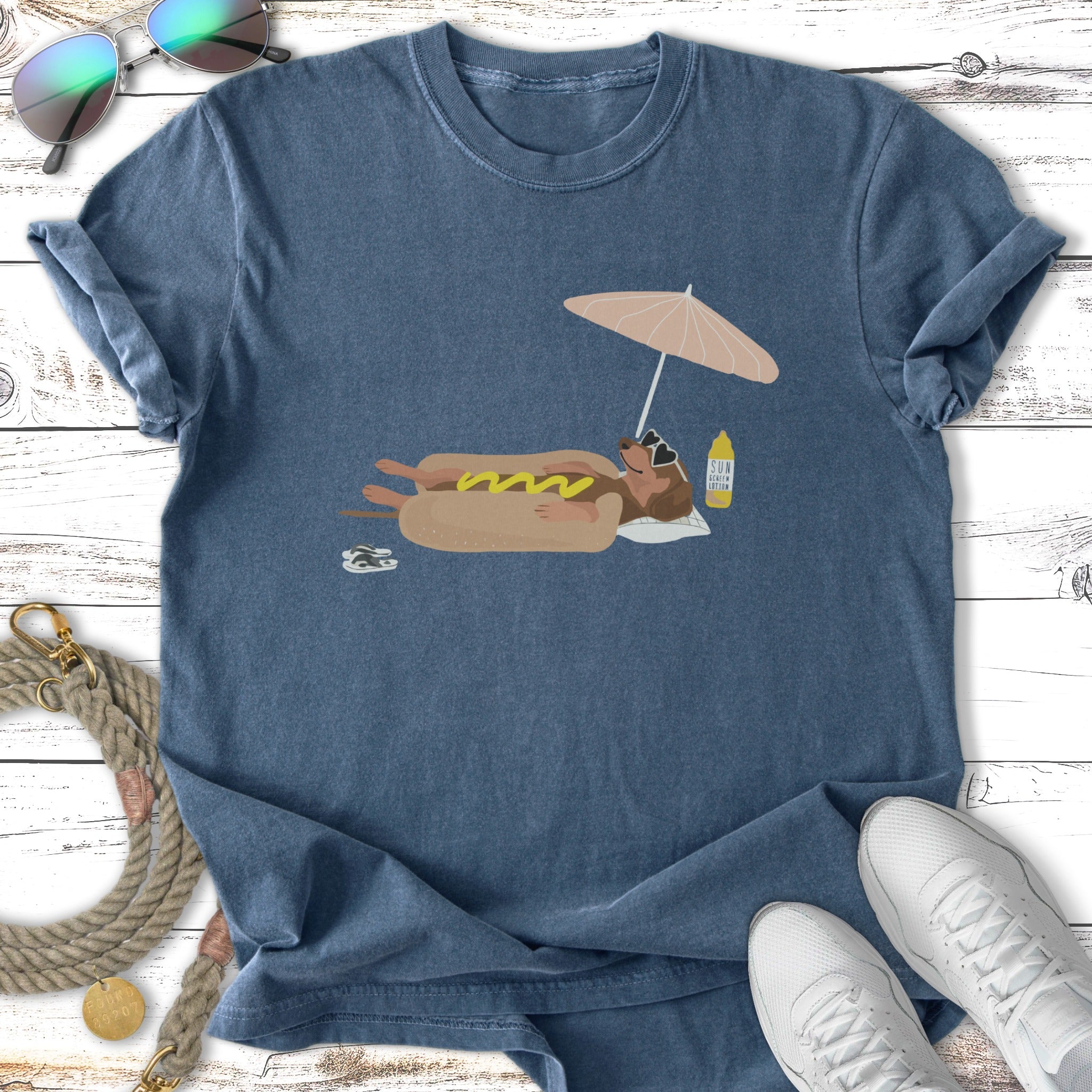 Dog in hot dog costume on float, under umbrella, with sunscreen bottle.