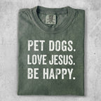 Green t-shirt with white text: PET DOGS. LOVE JESUS. BE HAPPY.