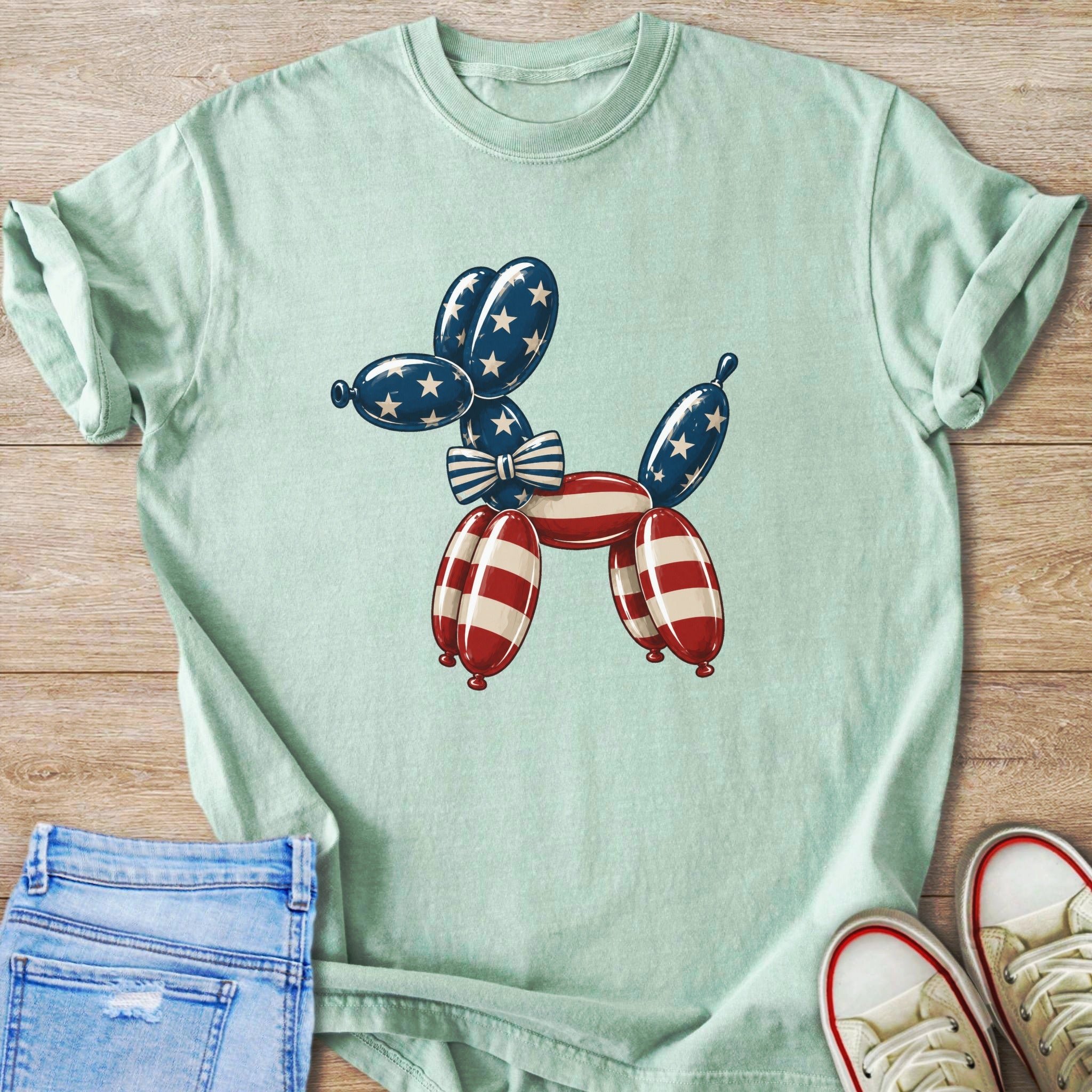 Light green t-shirt with a dog balloon graphic in red, white, and blue.