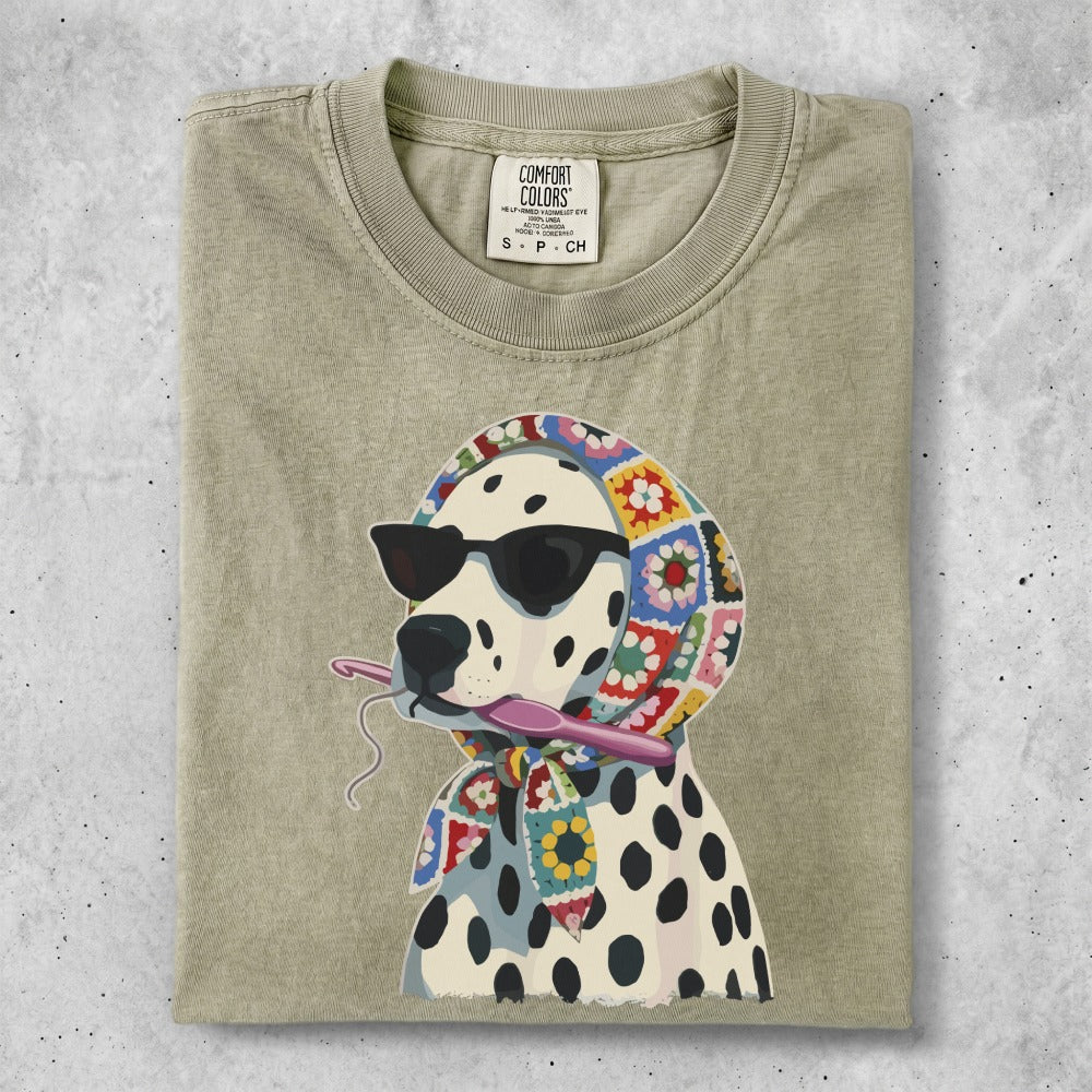 Dalmatian wearing sunglasses and a colorful crochet scarf, holding crochet hook.