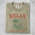 Green t-shirt with "RELAX" and a dog on a lounge chair.