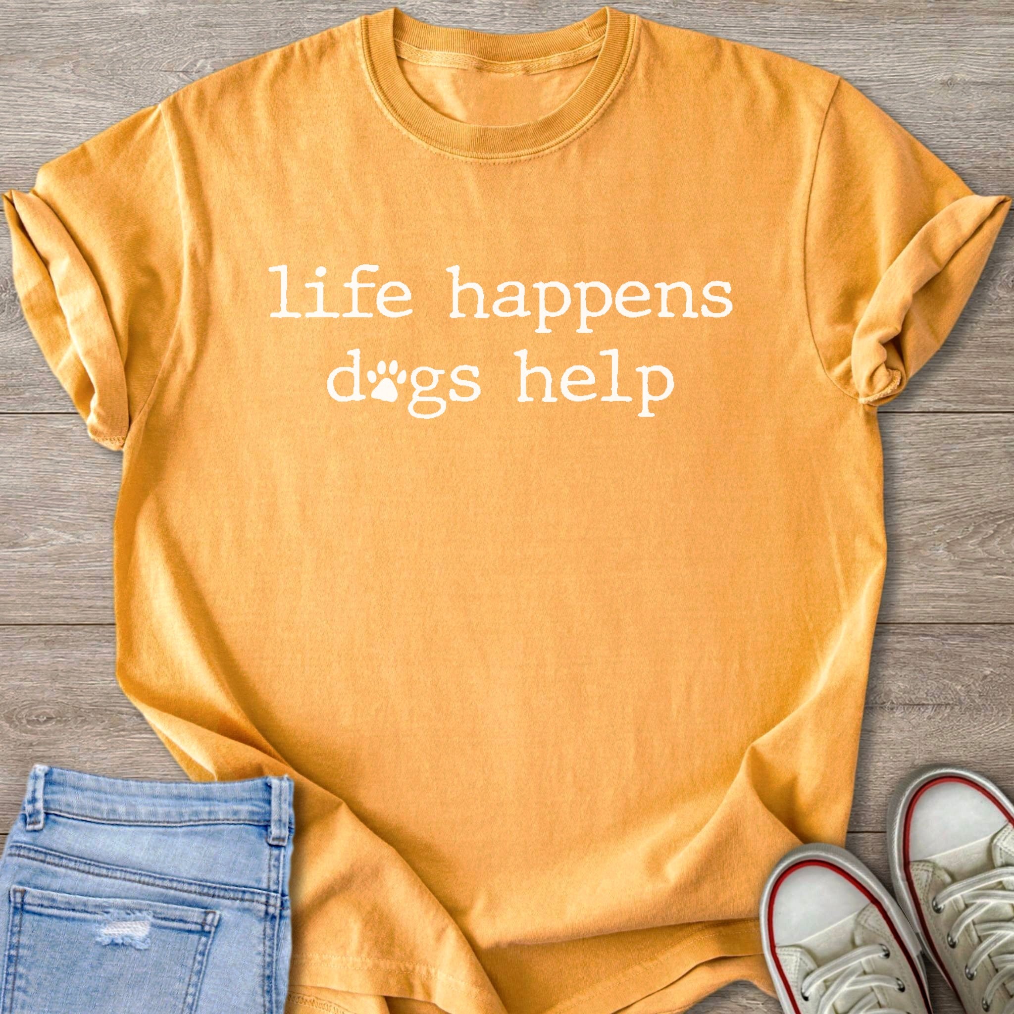 Orange t-shirt with white text "life happens dogs help" and paw prints.