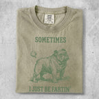 Green t-shirt with a distressed bulldog illustration and text "SOMETIMES I JUST BE FARTIN'".