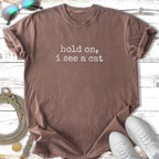 Brown t-shirt with "hold on, i see a cat" text.
