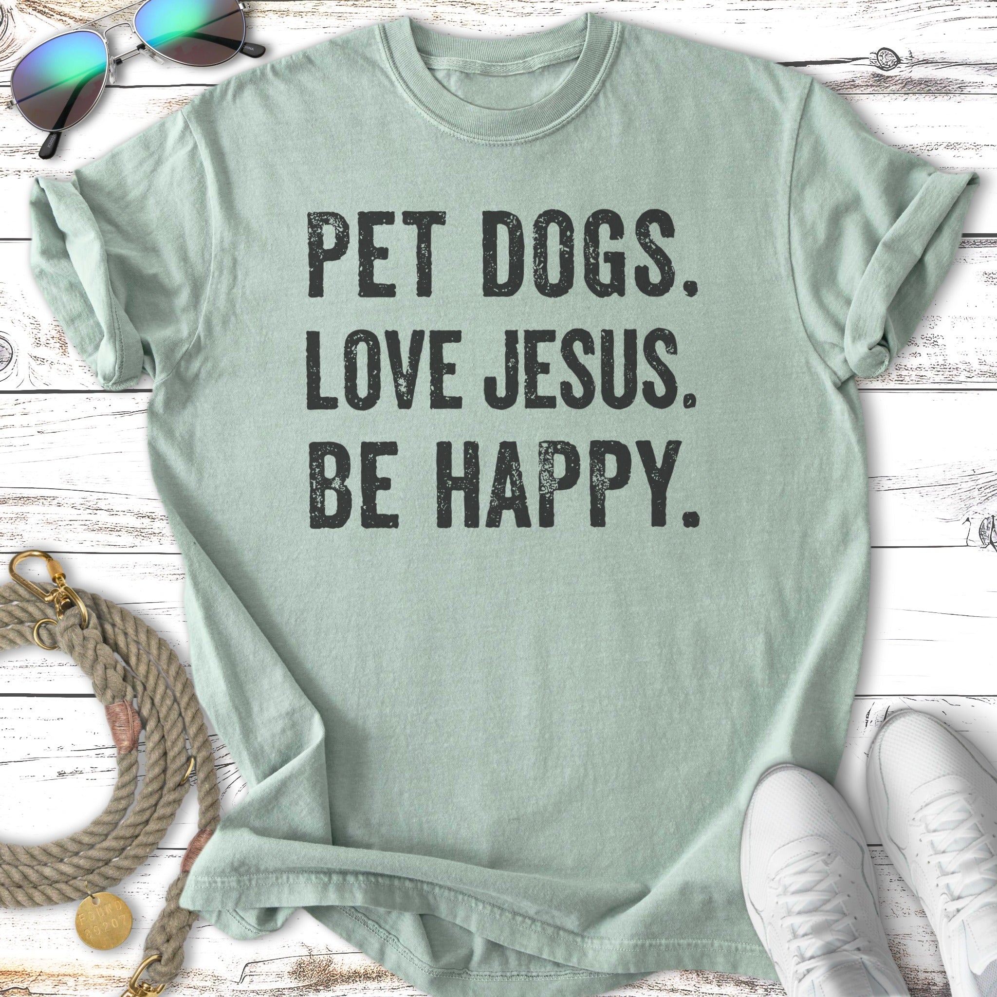 Light green t-shirt with "PET DOGS. LOVE JESUS. BE HAPPY." text.