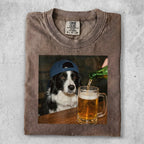 T-shirt with a graphic of a border collie wearing a blue baseball cap pouring beer.