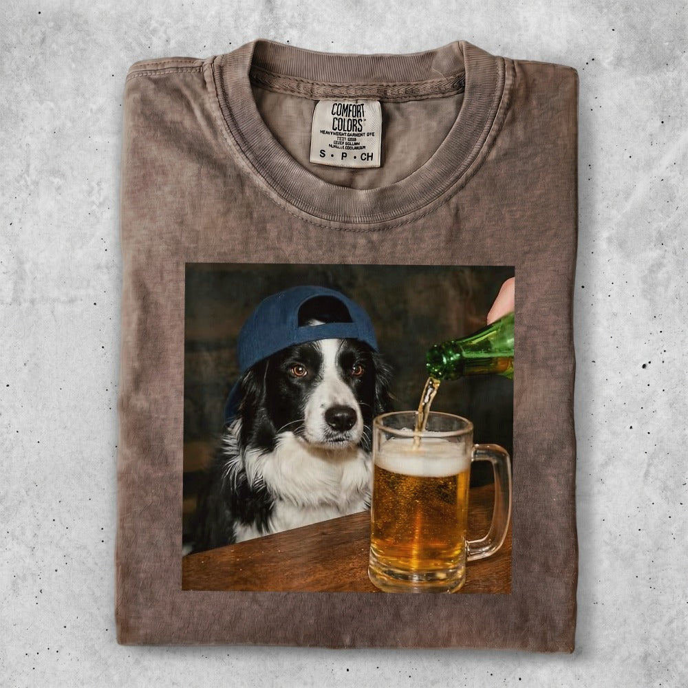 T-shirt with a graphic of a border collie wearing a blue baseball cap pouring beer.