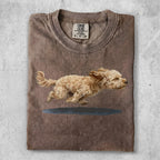 Brown t-shirt with a brown and white dog running across a blue puddle.