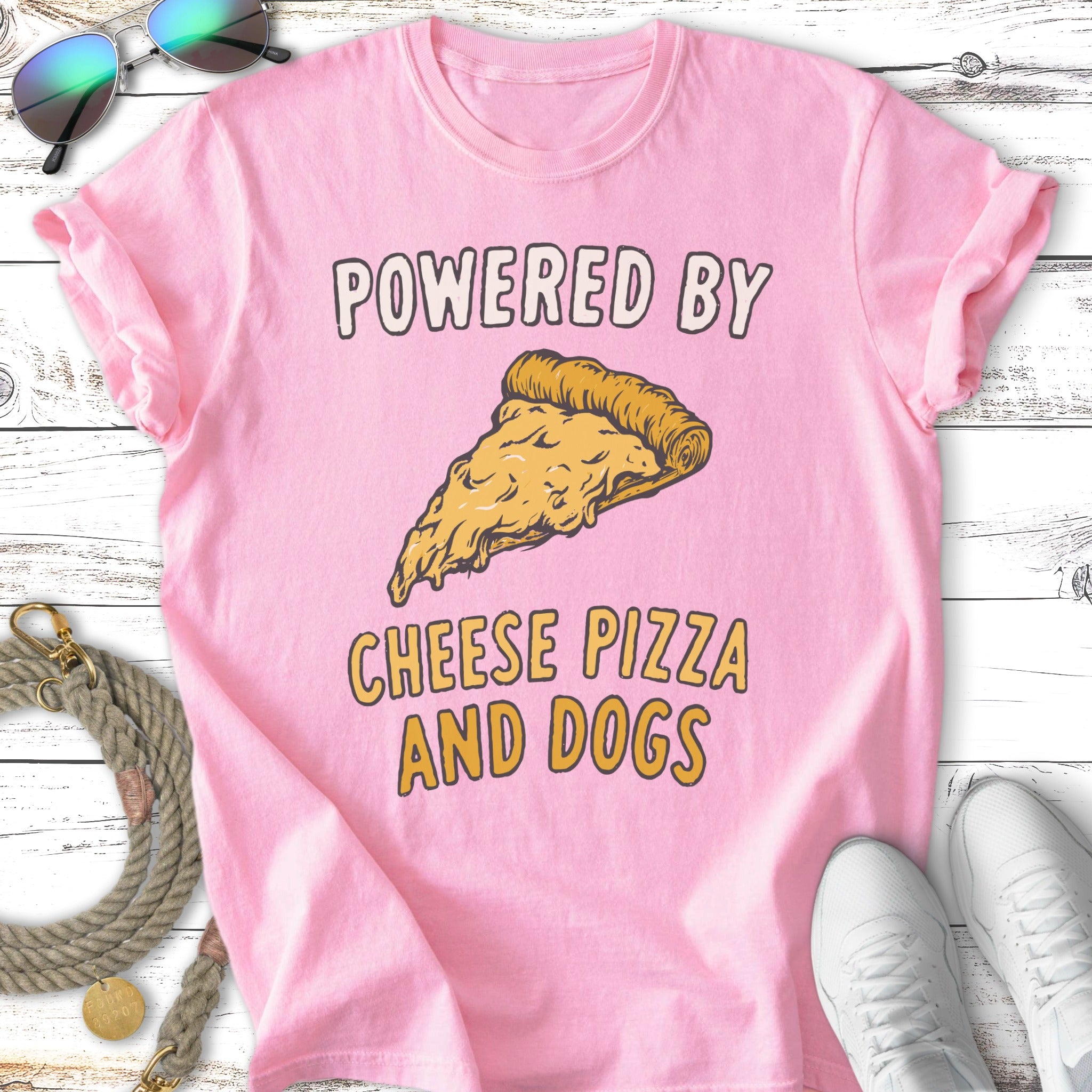 Pink t-shirt with "Powered by Cheese Pizza and Dogs" text and pizza slice graphic.