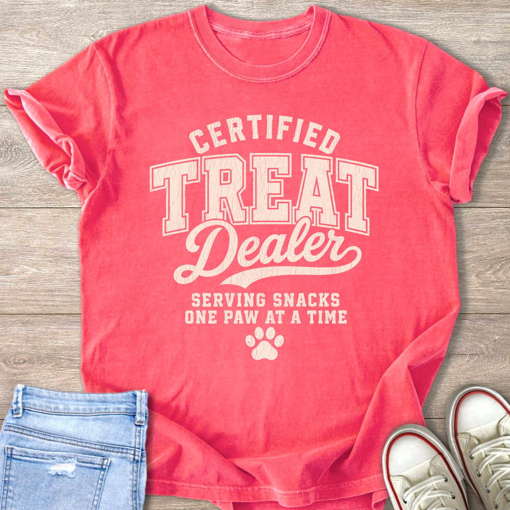Coral t-shirt with "Certified Treat Dealer Serving Snacks One Paw At A Time" text.