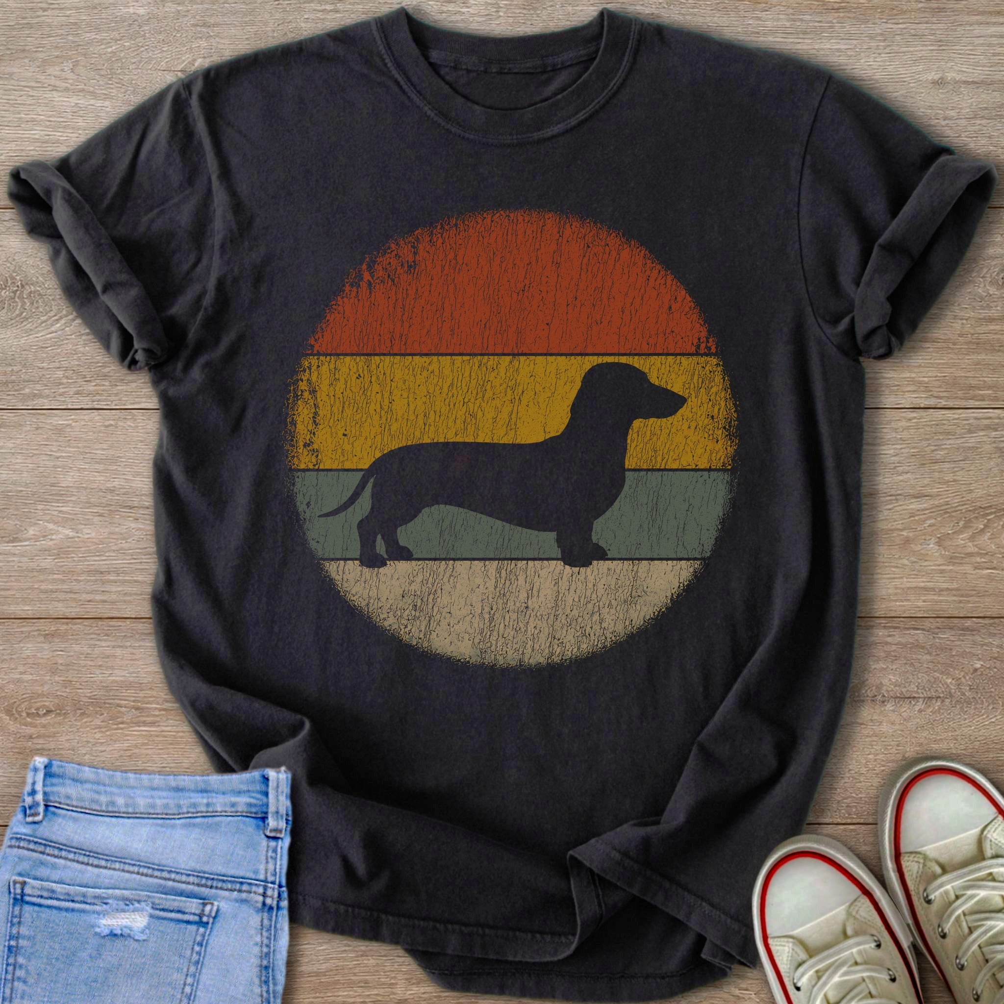 Black t-shirt with a dark dachshund silhouette on a vintage striped circle background.
