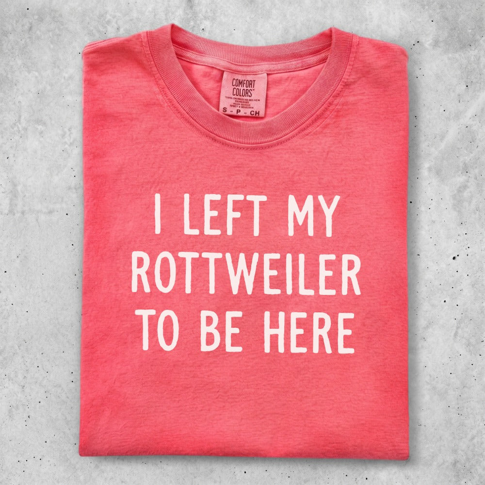 Red t-shirt with "I LEFT MY ROTTWEILER TO BE HERE" text.