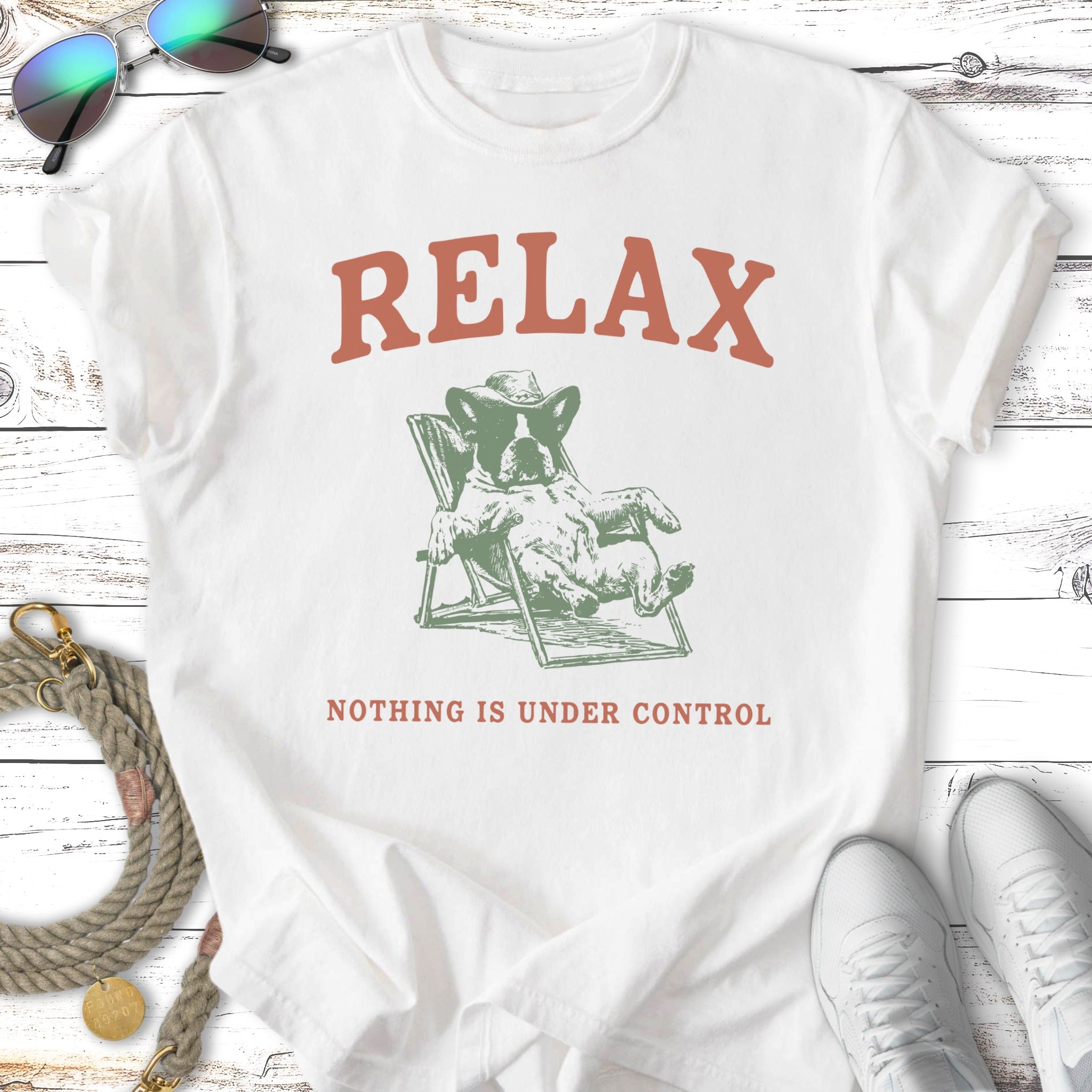 Dog wearing a hat relaxes in a chair with text "RELAX NOTHING IS UNDER CONTROL".