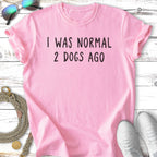 Pink t-shirt with "I WAS NORMAL 2 DOGS AGO" text and sunglasses.