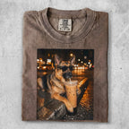German Shepherd wearing sunglasses drinks iced coffee in a city at night.