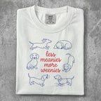 White t-shirt with dachshund illustrations and "less meanies, more weenies" text.