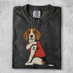 Beagle dog with "I Love Mom" tattoo on arm, wearing red t-shirt.