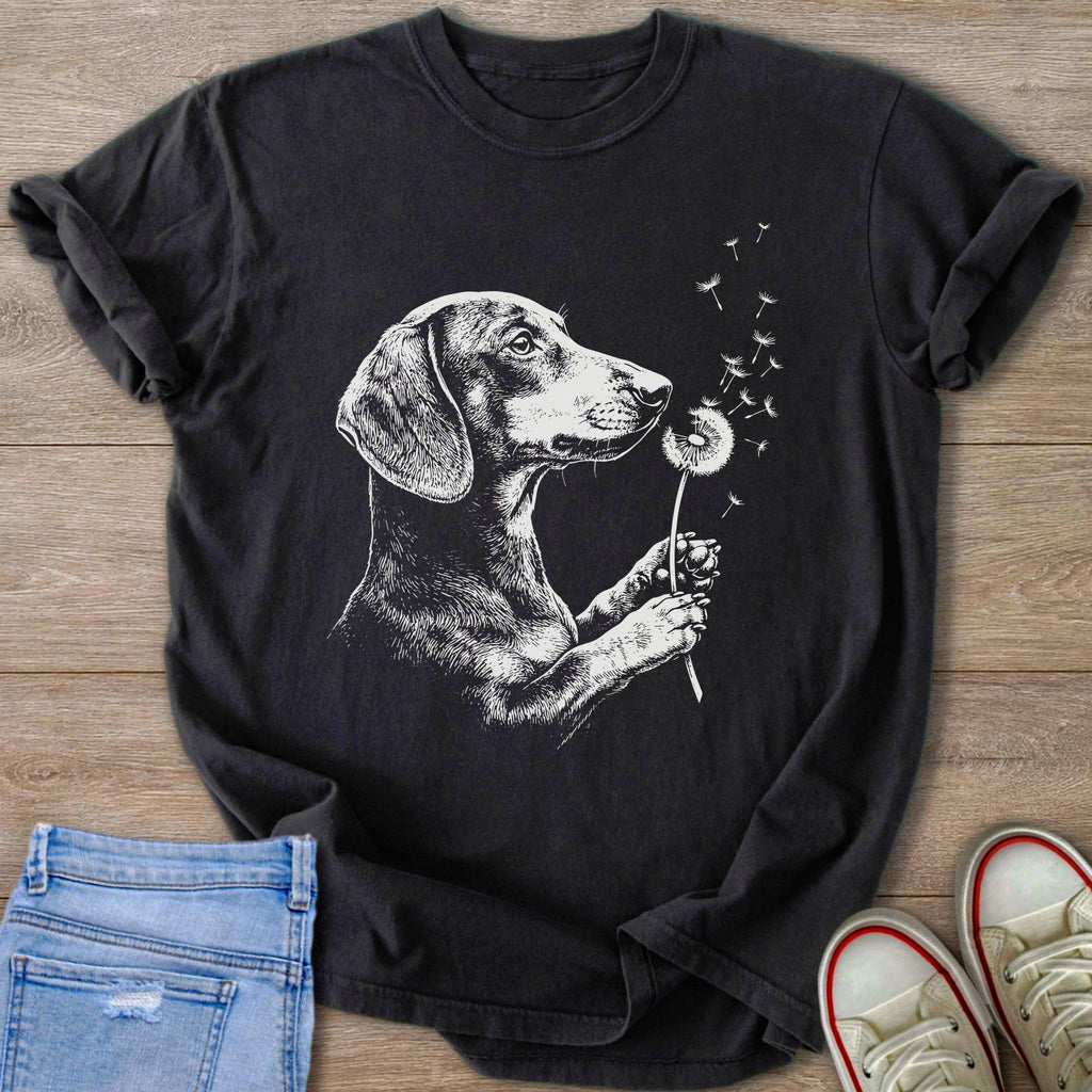 Black t-shirt with a white line drawing of a dachshund blowing dandelion seeds.