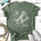 Green t-shirt with a silhouette of a Pomeranian dog and a forest scene.