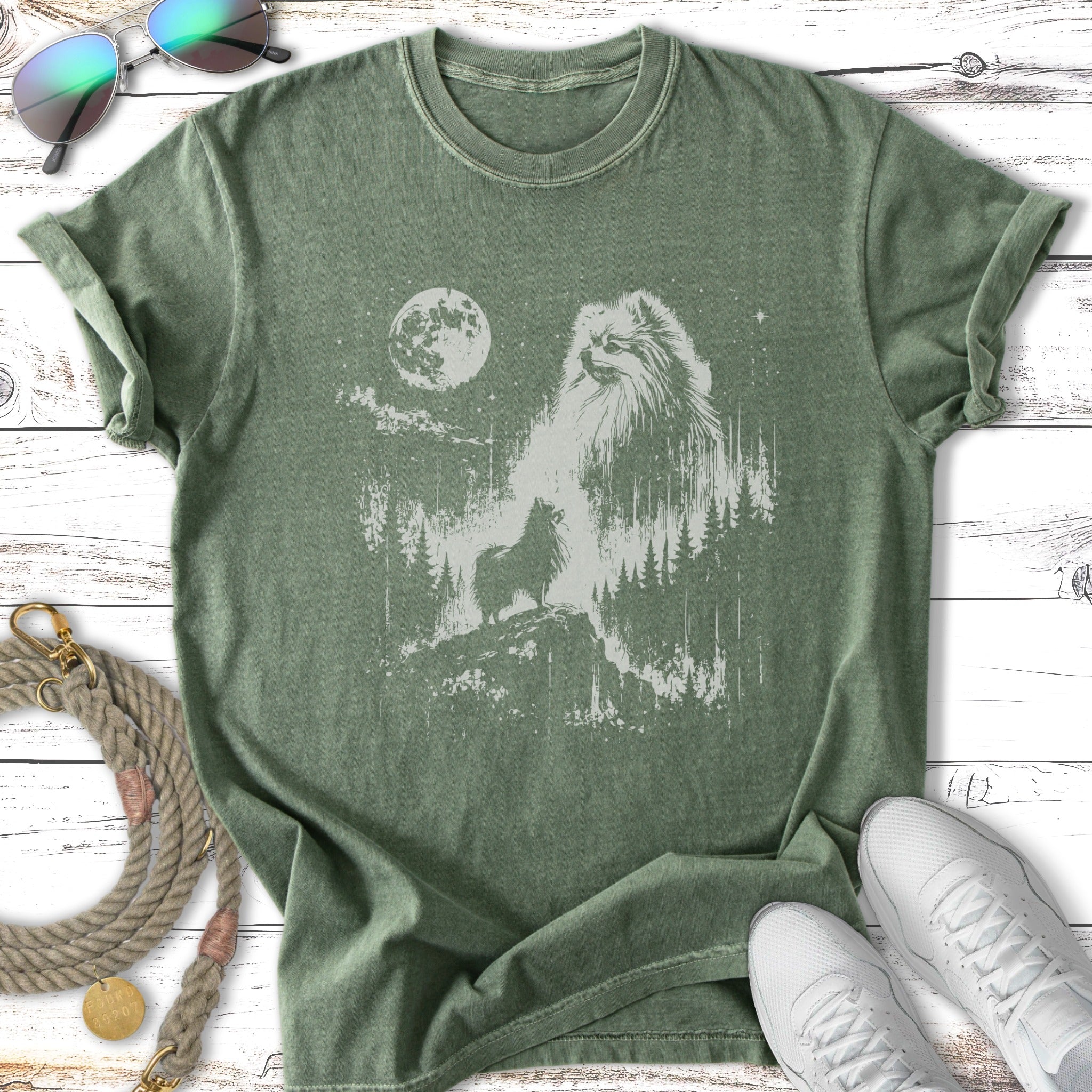 Green t-shirt with a silhouette of a Pomeranian dog and a forest scene.