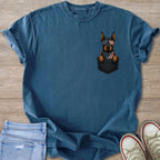 Blue t-shirt with a graphic of a dog wearing American flag sunglasses and bandana in a pocket.