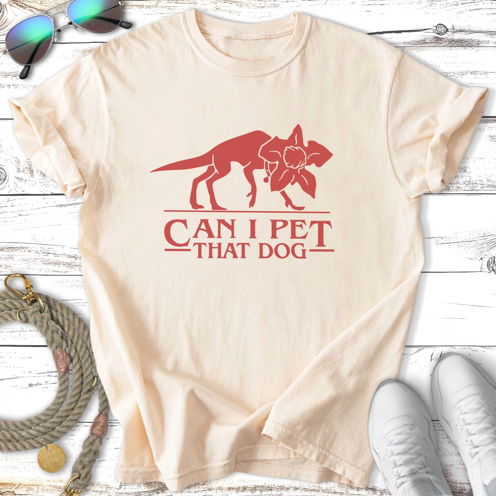 Cream t-shirt with red graphic of a dog and flower, text "CAN I PET THAT DOG".
