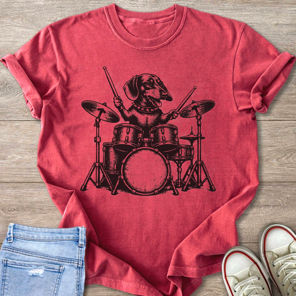 Dachshund playing drums graphic on a distressed red t-shirt with jeans and sneakers.