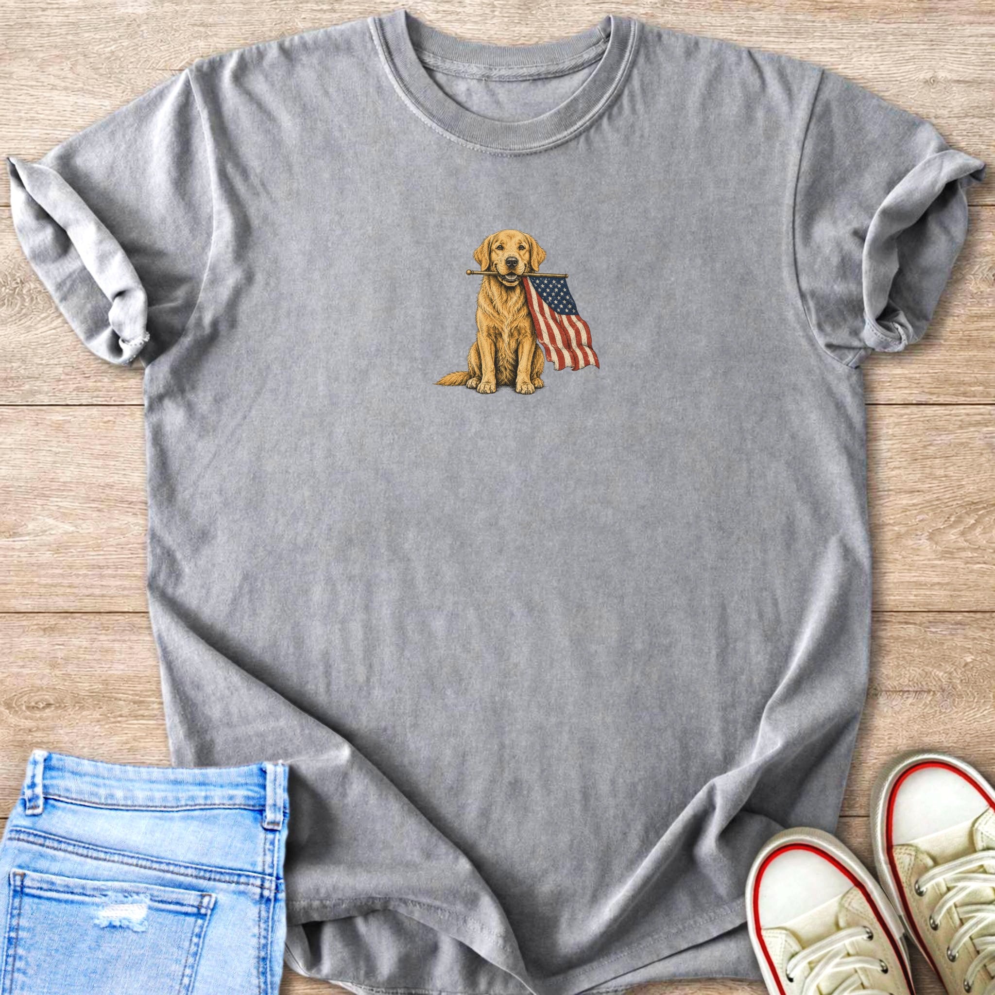 Grey t-shirt with illustration of a golden retriever holding an American flag in its mouth.