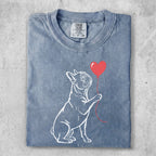 French bulldog with a red heart balloon against a faded blue t-shirt.