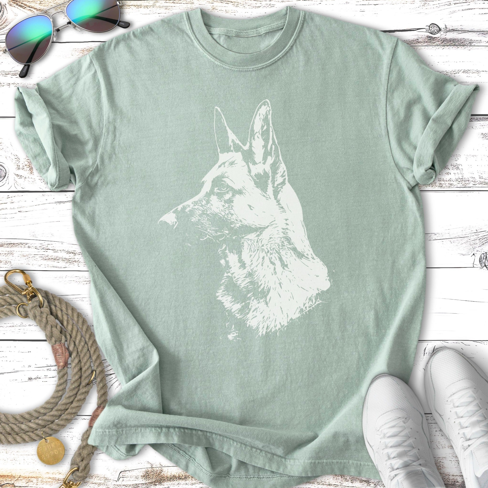 Light green t-shirt with white German Shepherd sketch and sunglasses, leash, and sneakers.