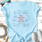 Light blue t-shirt with "less meanies more weenies" and cartoon dachshunds.