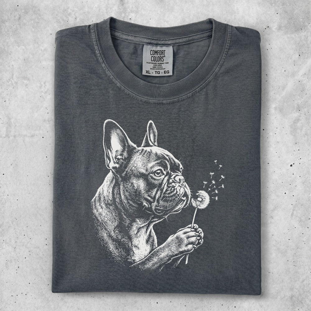 Dark grey t-shirt with a white sketch of a French bulldog blowing on a dandelion.