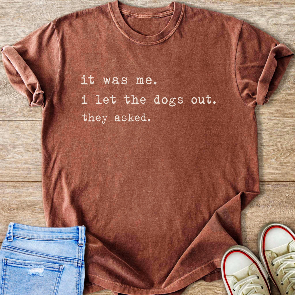 Brown t-shirt with white text reading "it was me. i let the dogs out. they asked."