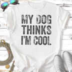 White t-shirt with "MY DOG THINKS I'M COOL" text.