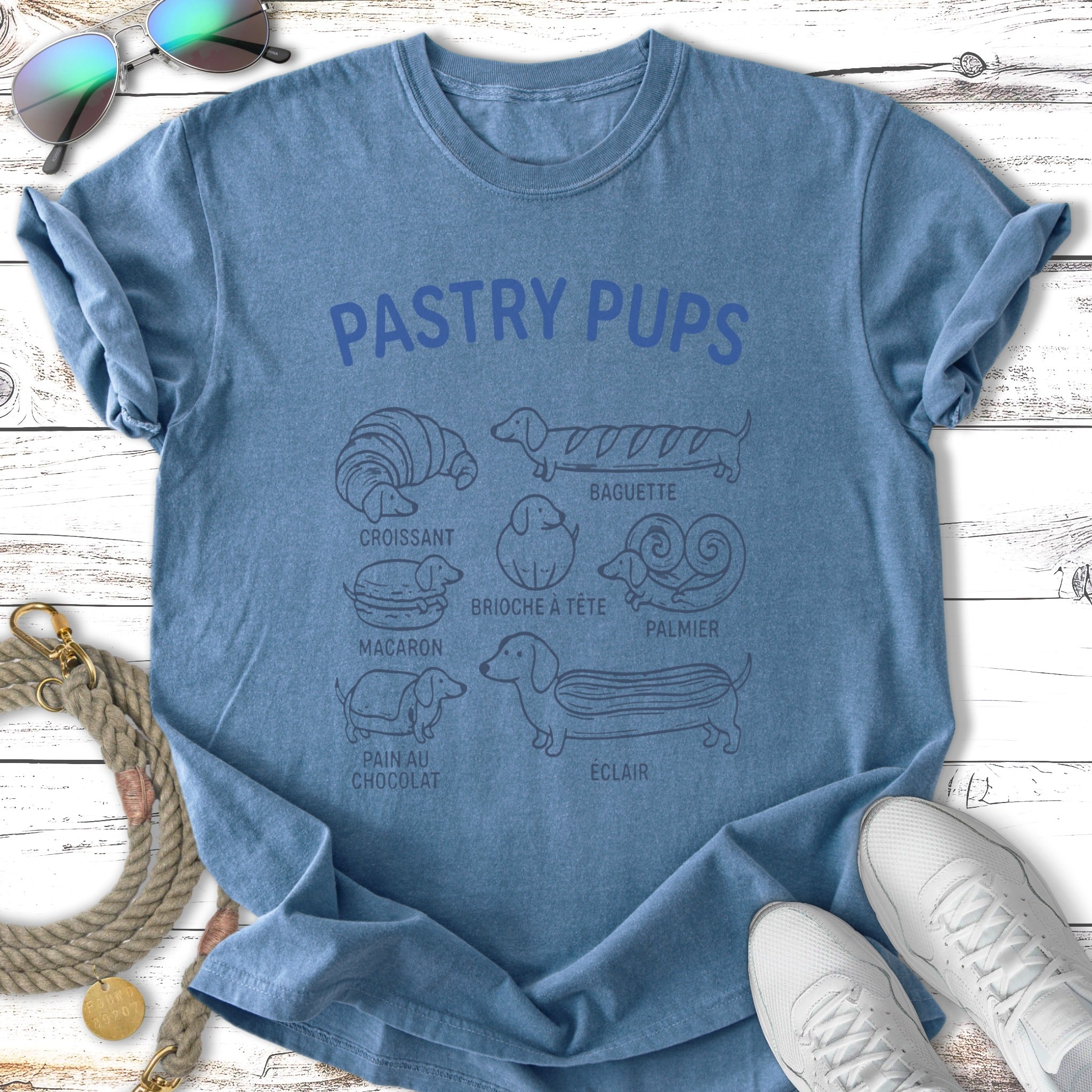 Blue t-shirt with "Pastry Pups" text and illustrations of various pastries with dog silhouettes.