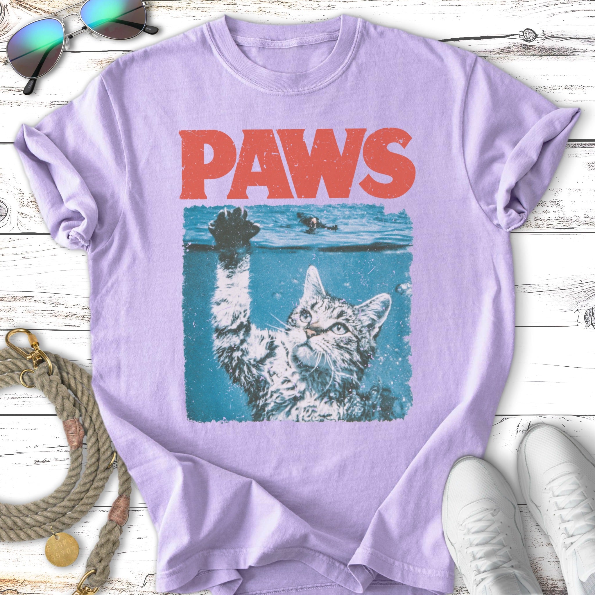 Cat reaching up from water with "PAWS" text above.