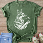 Green t-shirt with a white line drawing of a German Shepherd holding a dandelion.