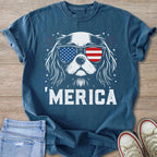 Blue shirt with white graphic of dog wearing American flag sunglasses and text "MERICA".