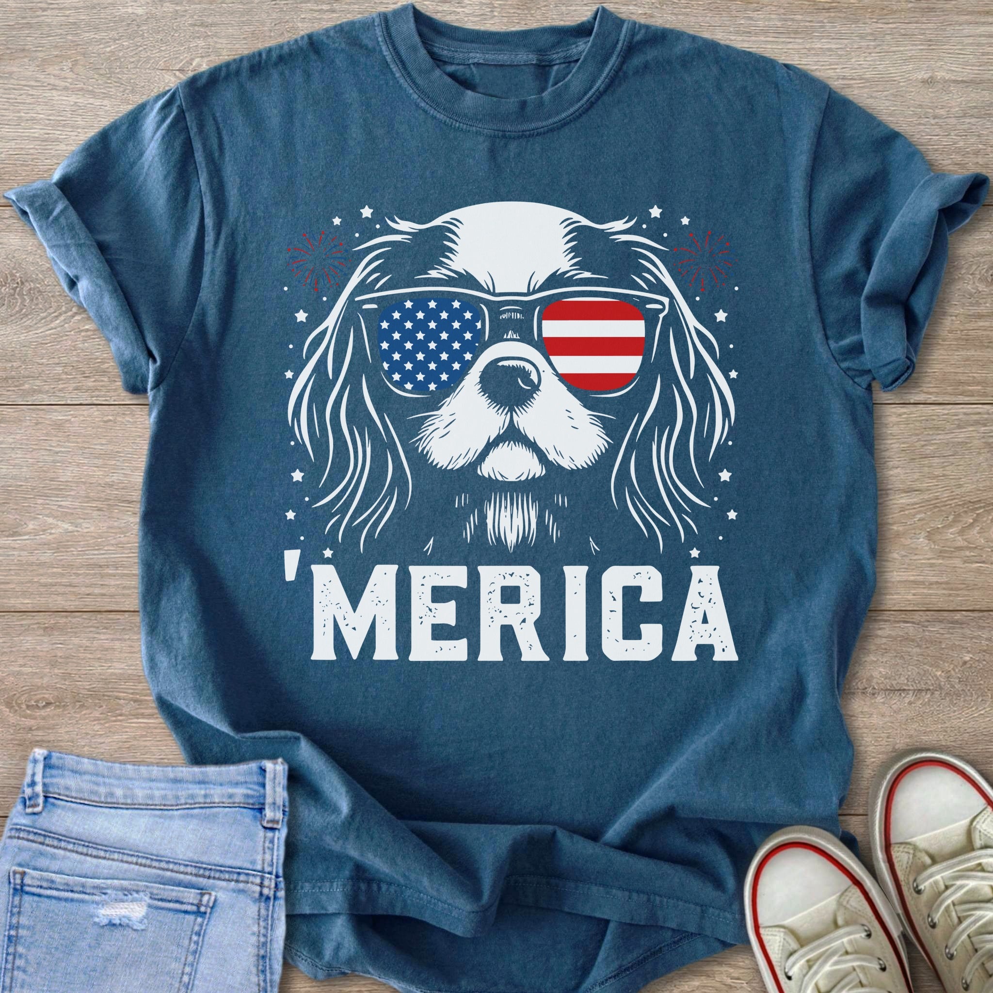 Blue shirt with white graphic of dog wearing American flag sunglasses and text "MERICA".