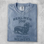 Blue t-shirt with "Real Men Play With Their Wieners" and a dachshund graphic.