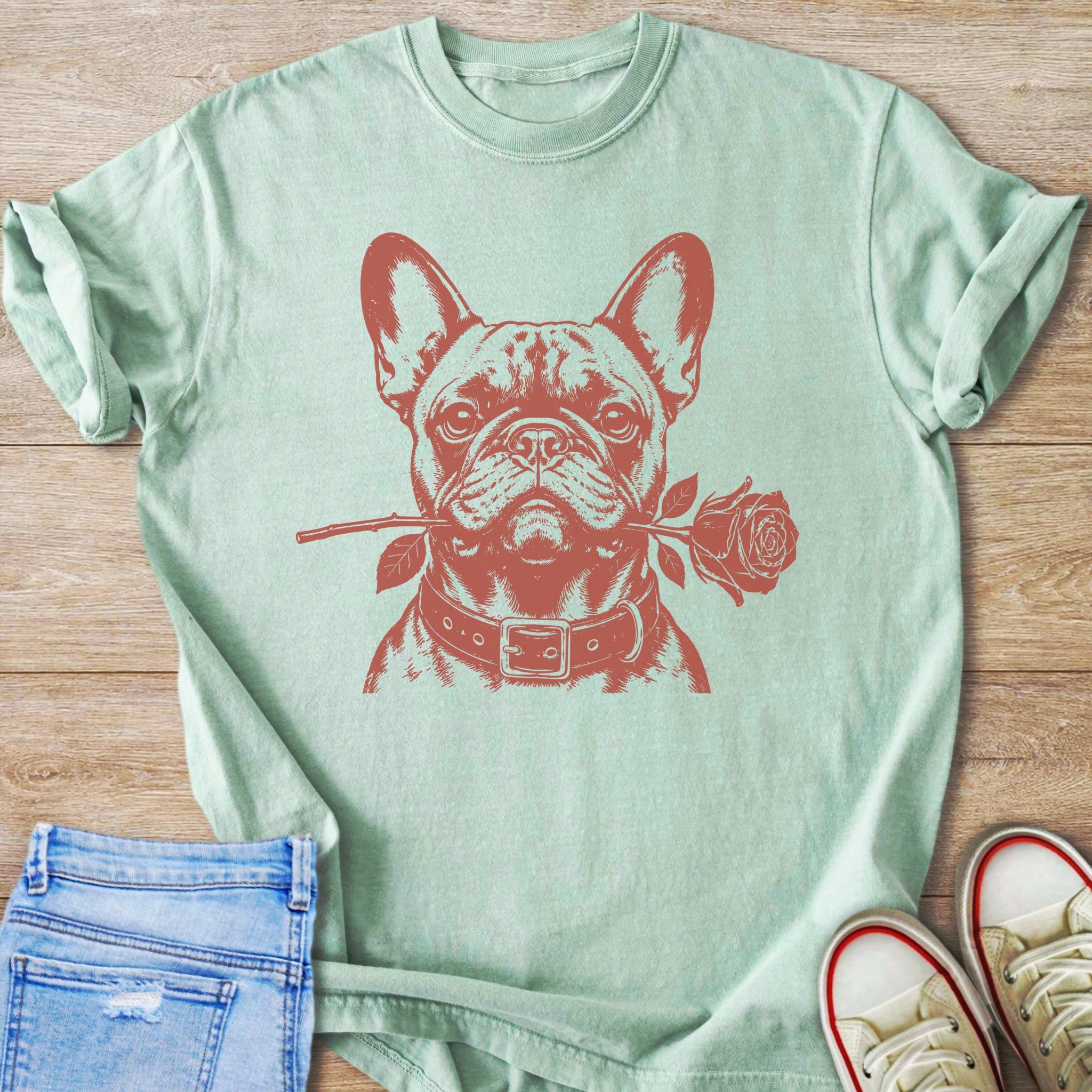 Light green t-shirt with a red graphic of a French bulldog holding a rose in its mouth.