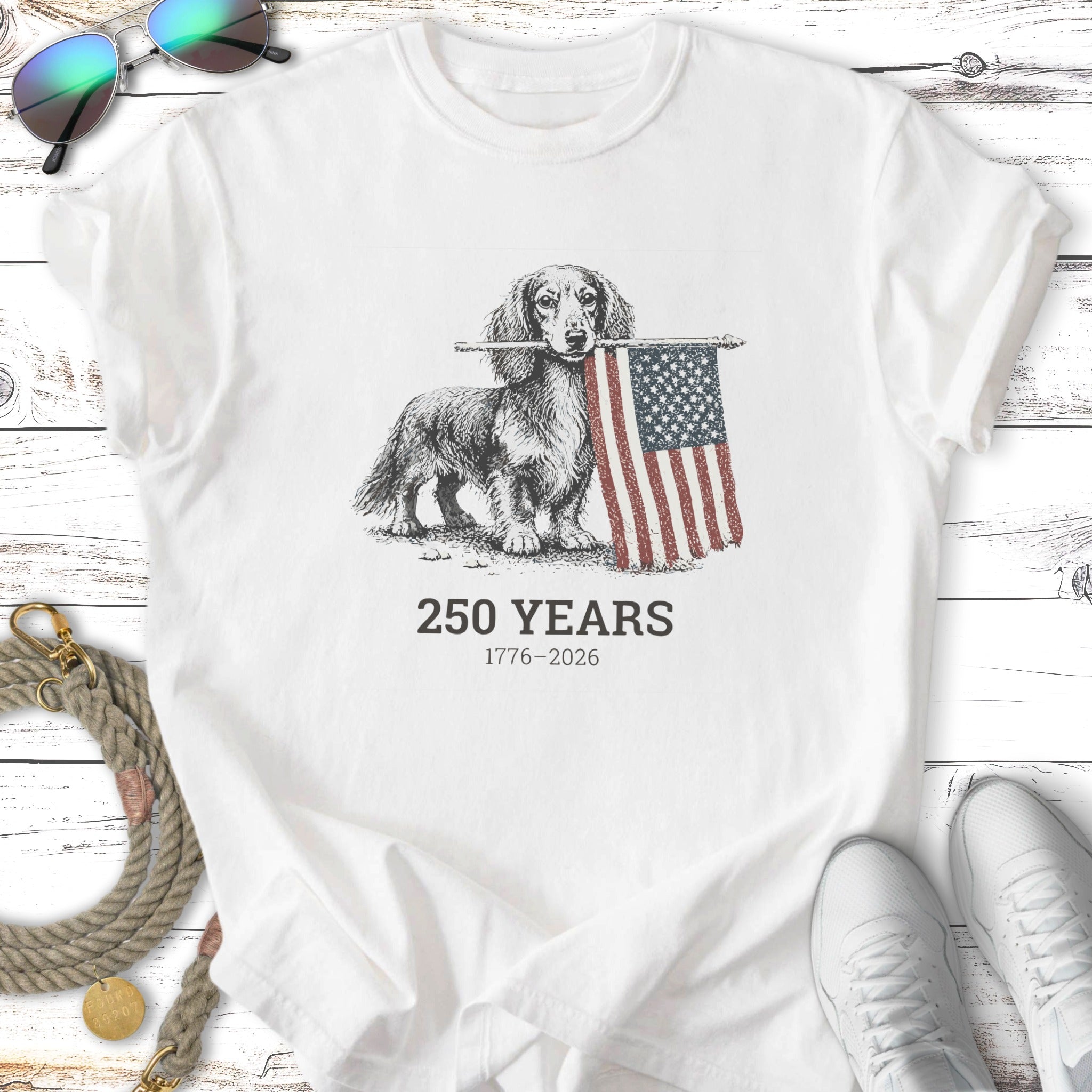 Dachshund holding American flag; 250 Years 1776-2026 text.