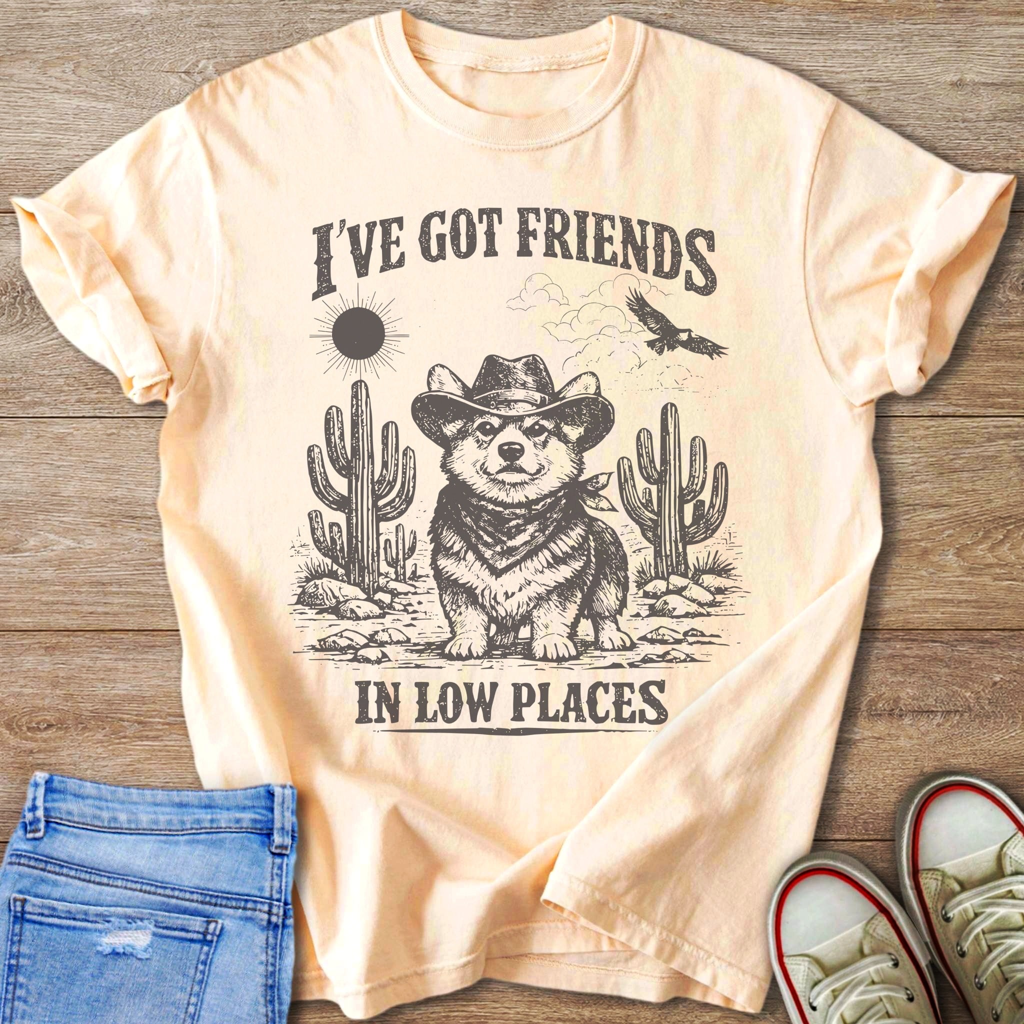 Corgi wearing cowboy hat and bandana with desert graphic and text "I'VE GOT FRIENDS IN LOW PLACES".