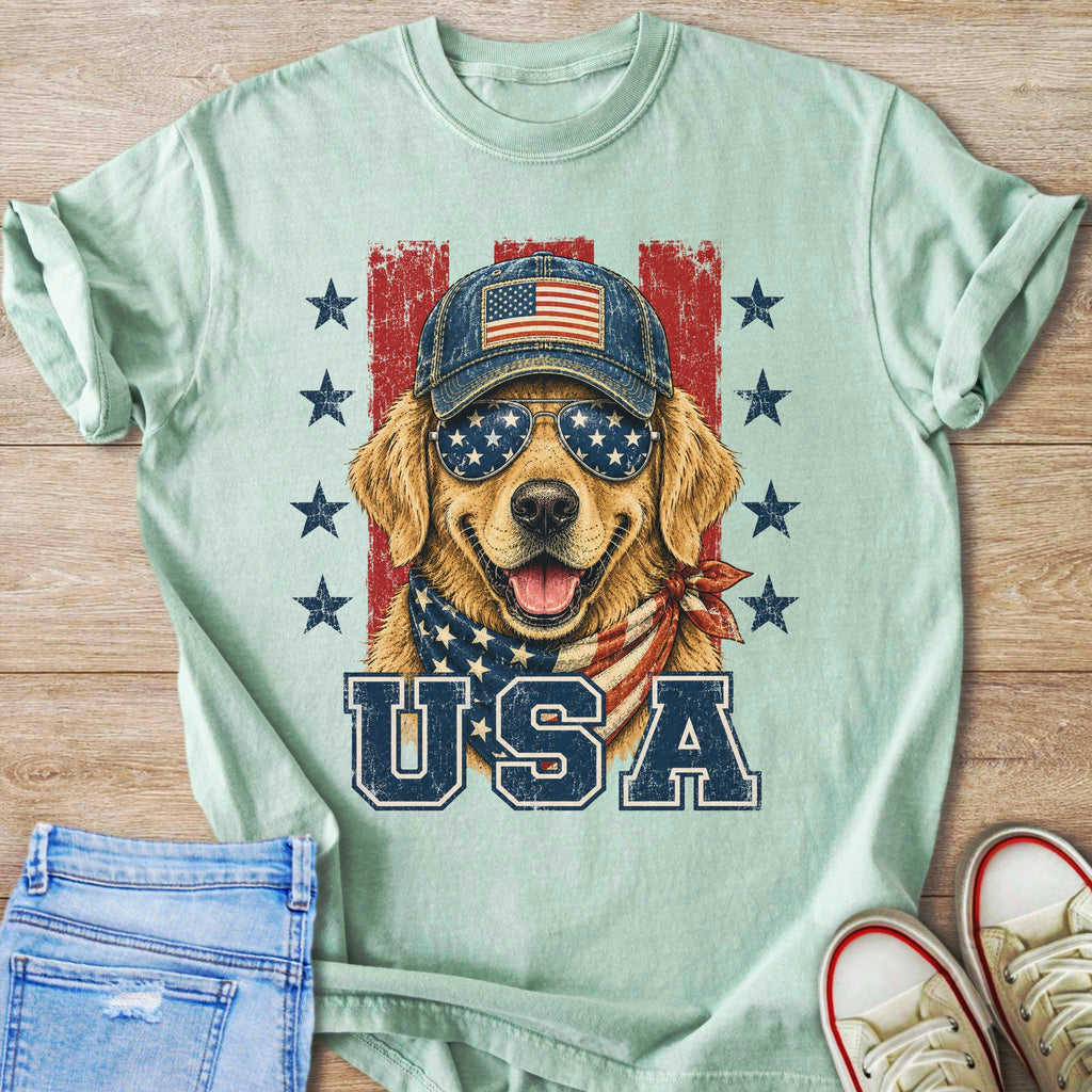 Golden retriever wearing a baseball cap, sunglasses, and bandana with USA text.
