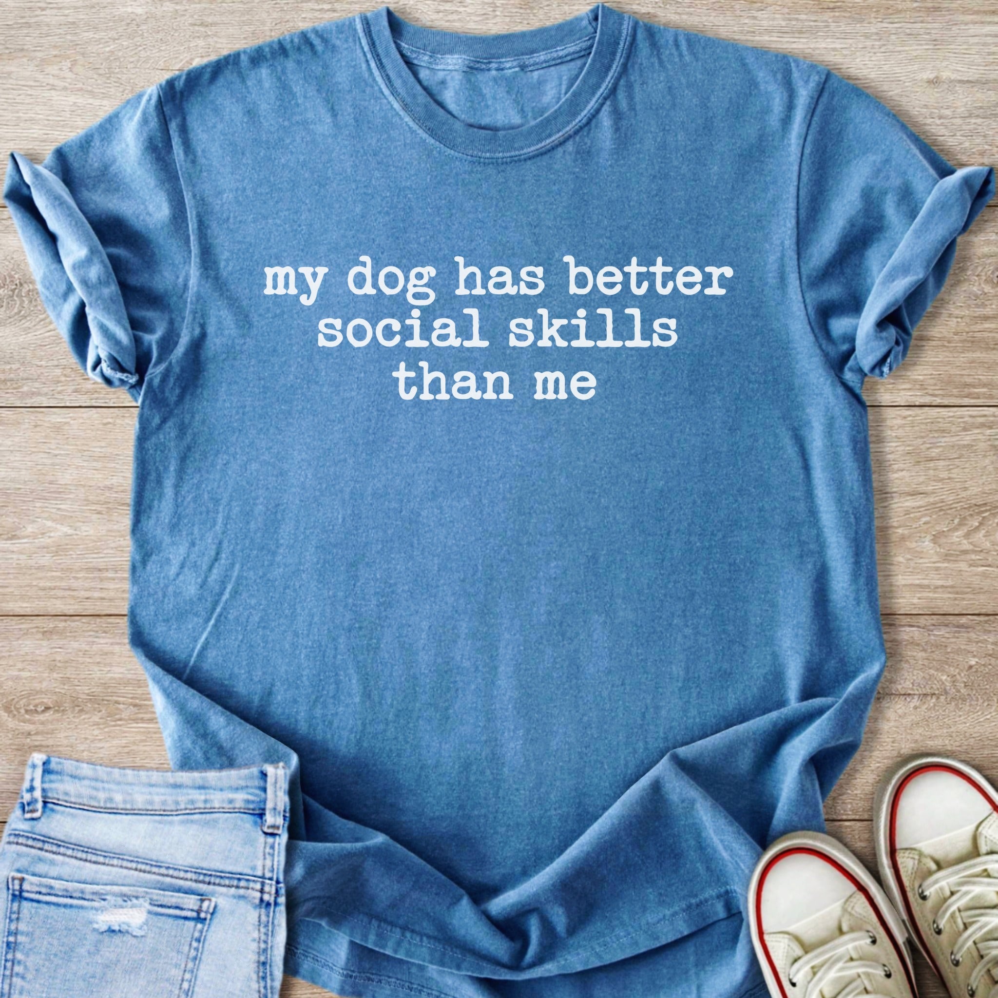 Blue t-shirt with white text that reads "my dog has better social skills than me."