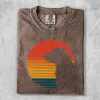 Brown t-shirt with a silhouette of a dog's head against a retro sunset graphic.