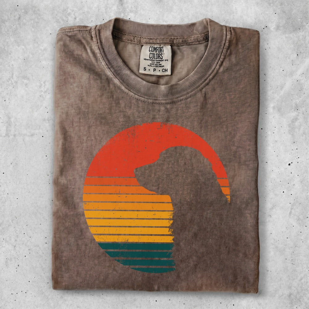 Brown t-shirt with a silhouette of a dog's head against a retro sunset graphic.