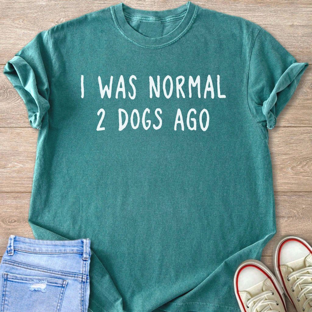 Teal t-shirt with white text "I WAS NORMAL 2 DOGS AGO".